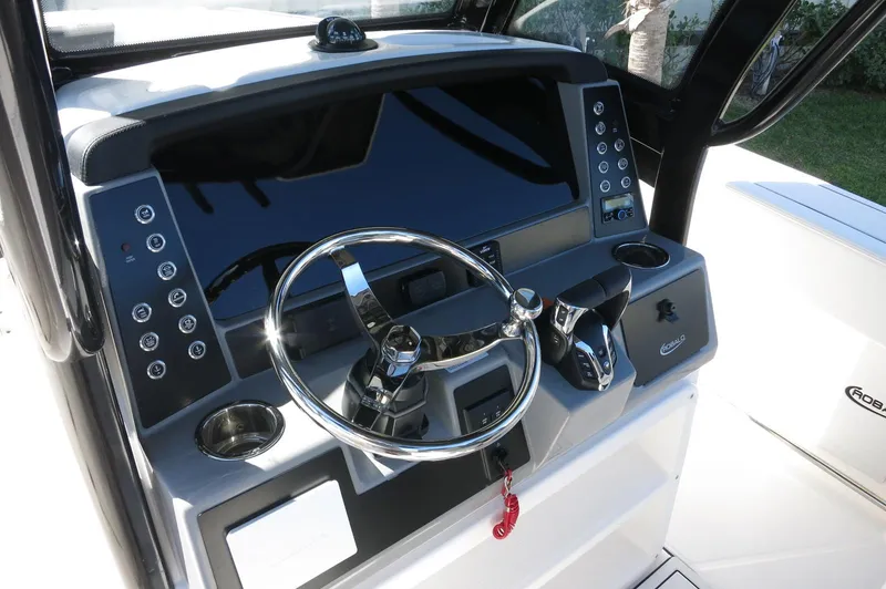 Slide: The Image of 2025 Robalo R250 Center Console boat dashboard with steering wheel and controls. - 37