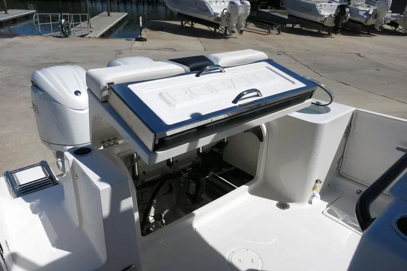 Slide: The Image of 2025 Robalo R250 Center Console boat with open storage compartment at dock. - 45