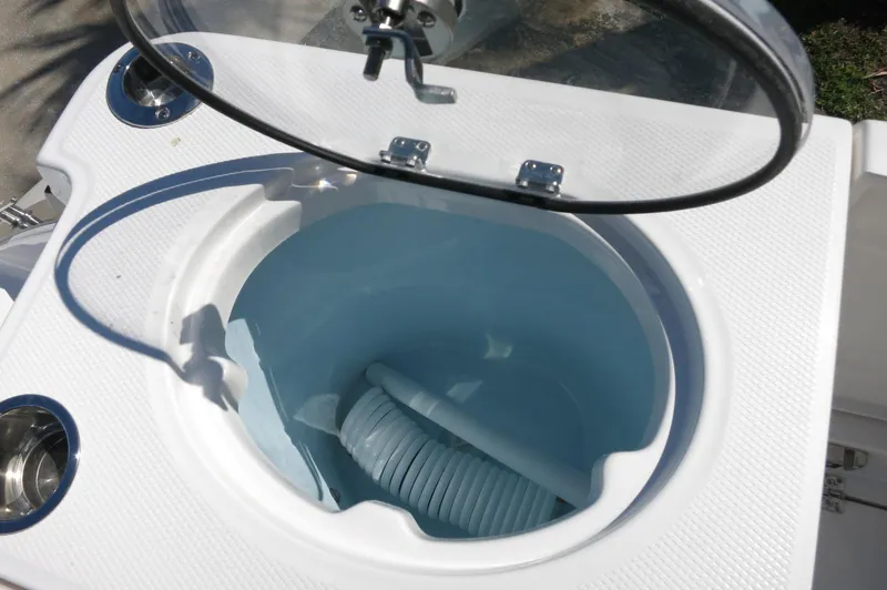 Slide: The Image of 2025 Robalo R250 Center Console livewell with open lid and visible hose. - 46