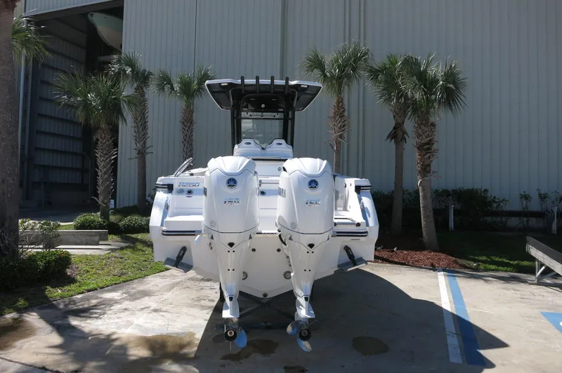 Slide: The Image of 2025 Robalo R250 Center Console boat with dual engines, parked outdoors. - 7