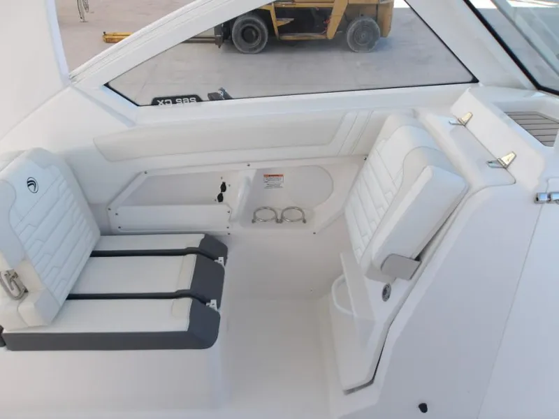 Slide: The Image of 2025 Edgewater 262 CX boat interior with white seating and cup holders. - 29