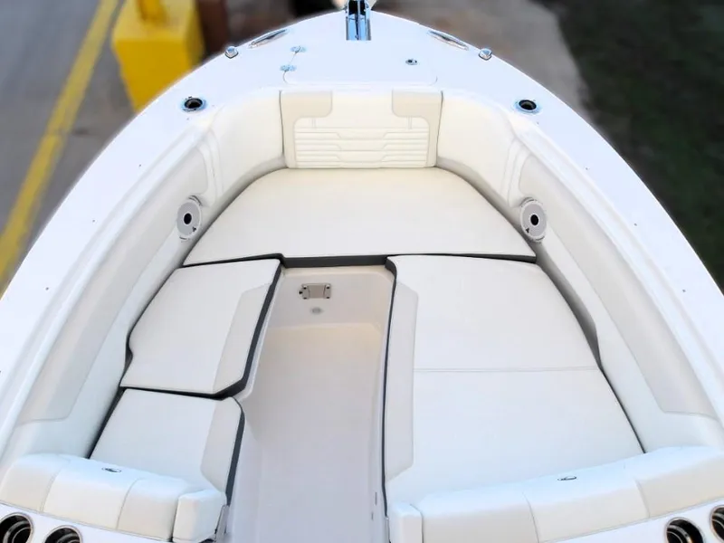 Slide: The Image of 2025 Edgewater 262 CX boat interior with white cushioned seating and storage compartments. - 3