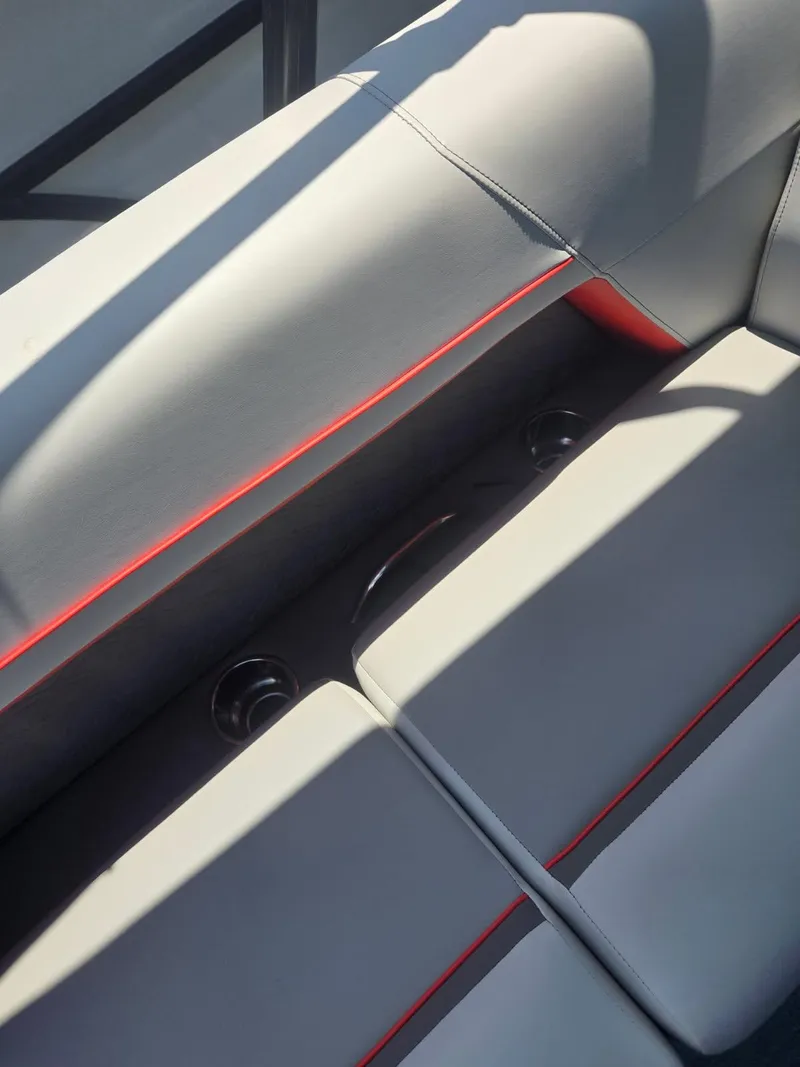 Slide: The Image of 2025 Quest 22rls interior seating with red accents and cup holders. - 17