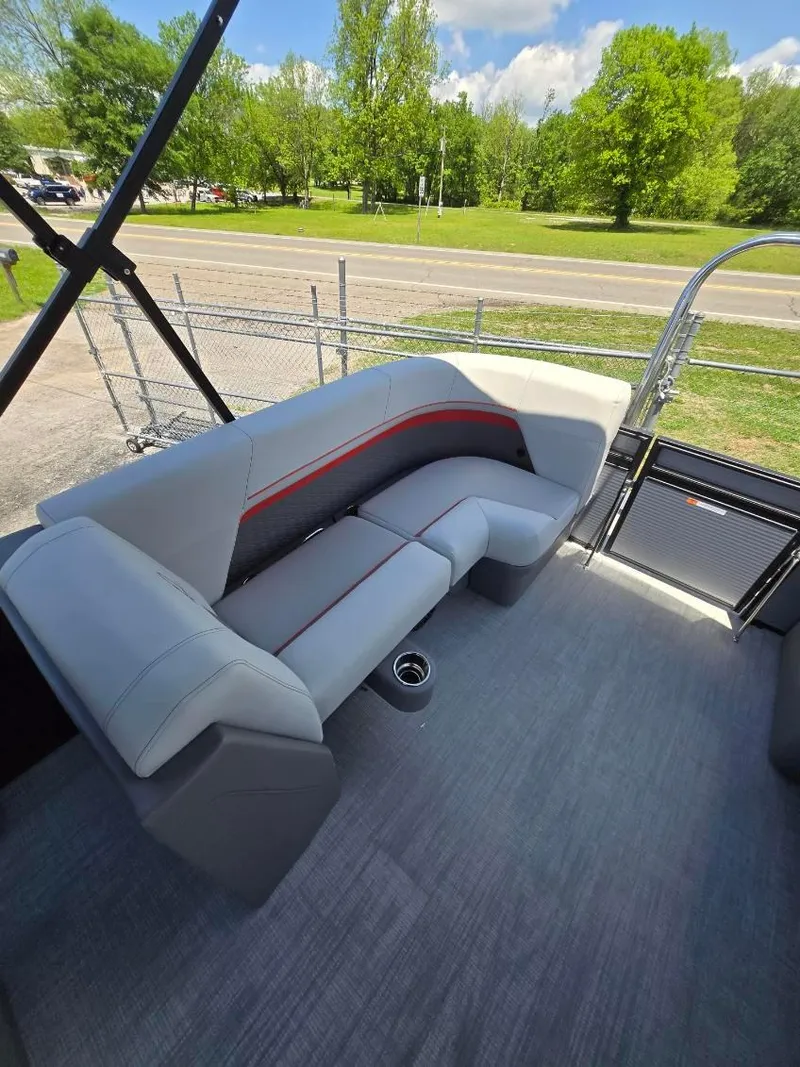Slide: The Image of 2025 Quest 22rls boat interior with gray seating and red accents, set against a scenic outdoor backdrop. - 5