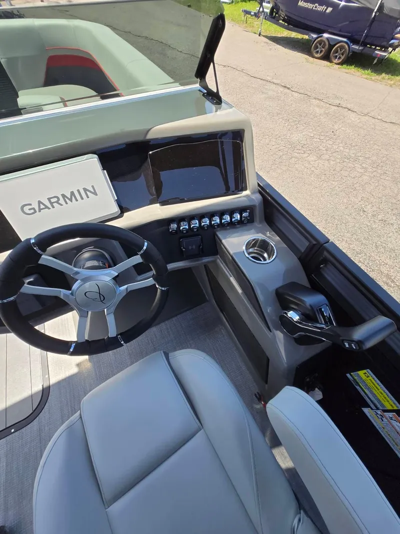 Slide: The Image of 2025 Quest 22rls boat cockpit with Garmin navigation, steering wheel, and control panel. - 9