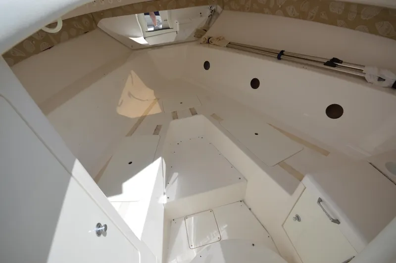 Slide: The Image of 2004 Intrepid 323 Cuddy cabin interior, featuring white seating and storage compartments. - 10