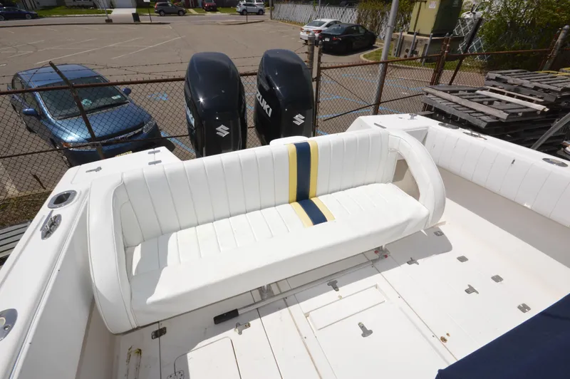 Slide: The Image of 2004 Intrepid 323 Cuddy boat with white seating and dual Suzuki outboard engines. - 11