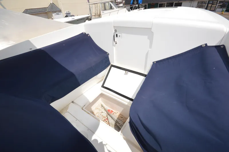 Slide: The Image of 2004 Intrepid 323 Cuddy boat interior with blue seating and storage compartment. - 15