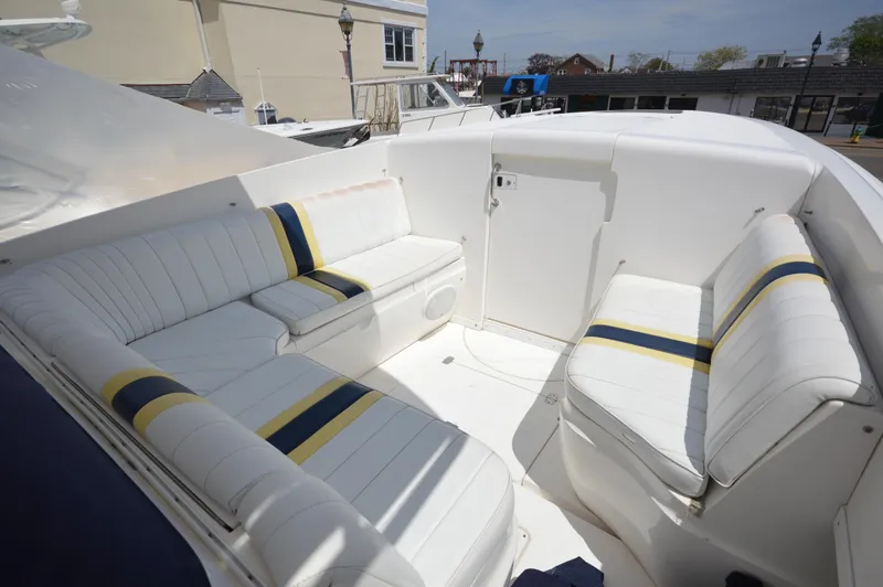 Slide: The Image of 2004 Intrepid 323 Cuddy boat interior with white and striped seating. - 17