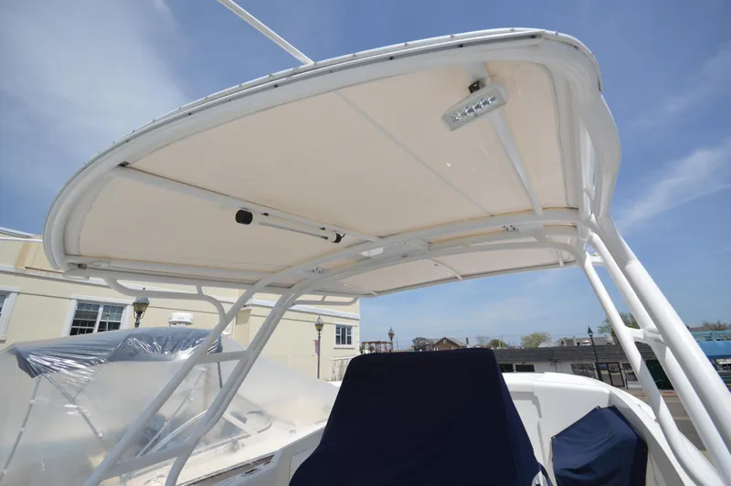 Slide: The Image of 2004 Intrepid 323 Cuddy boat with a white canopy and blue seating. - 21