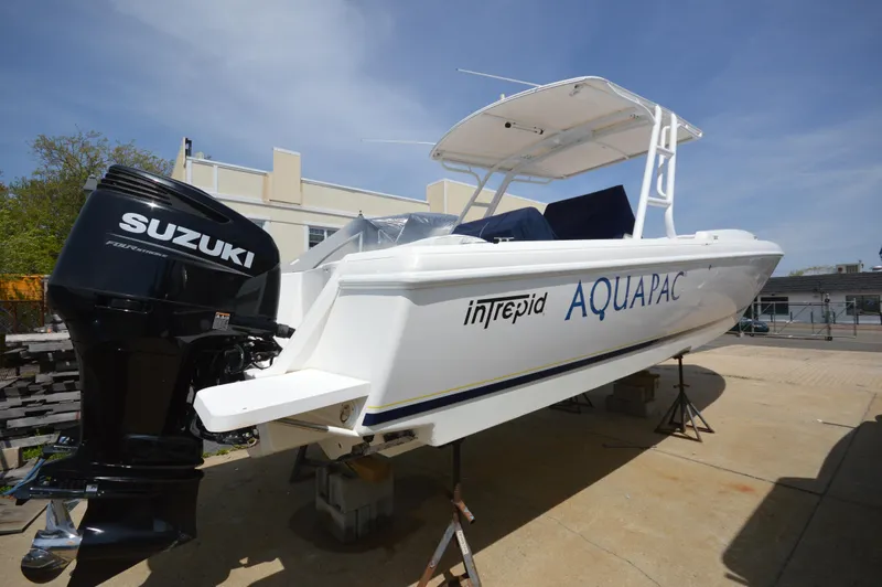 Slide: The Image of 2004 Intrepid 323 Cuddy boat with Suzuki outboard motor, docked outdoors. - 22