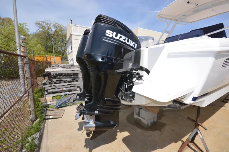 Slide: The Image of 2004 Intrepid 323 Cuddy with Suzuki outboard motor, docked outdoors. - 6