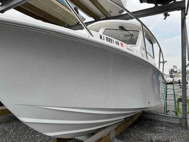 The Image of 2022 NorthCoast 255 Cabin boat on dry dock, showcasing sleek hull design. - 0