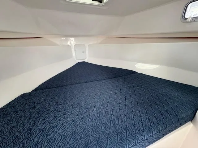 Slide: The Image of 2022 NorthCoast 255 Cabin interior with blue cushioned sleeping area. - 16