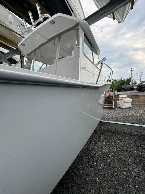 Slide: The Image of 2022 NorthCoast 255 Cabin boat with sleek design, docked outdoors. - 2