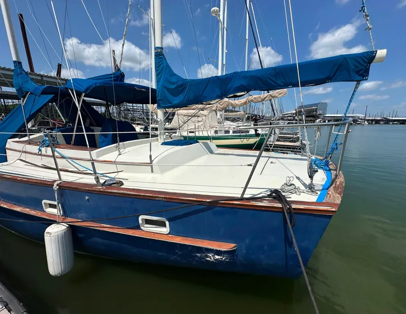 Slide: The Image of 1982 Irwin 46 sailboat docked, featuring blue hull and sails under a clear sky. - 11