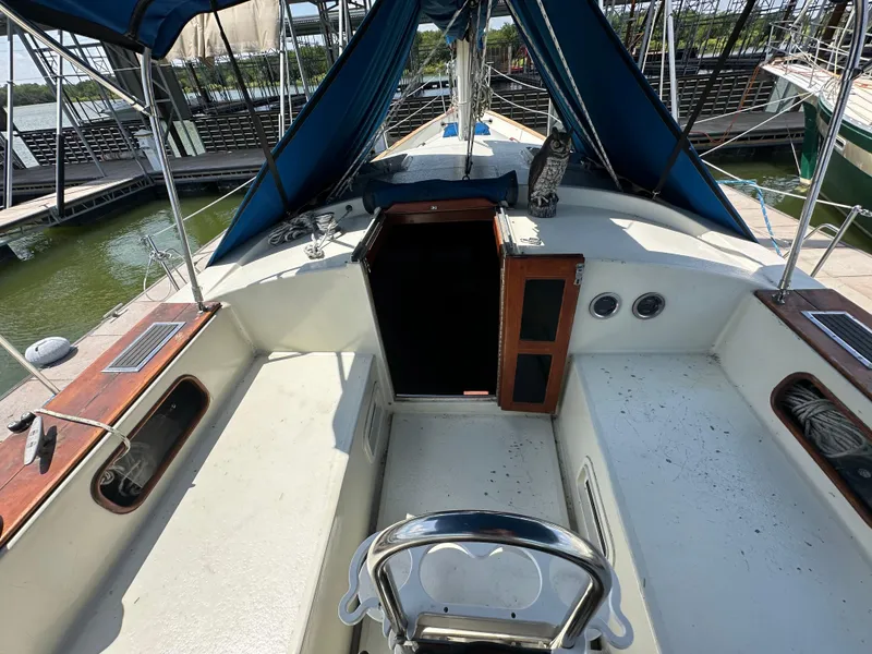 Slide: The Image of 1982 Irwin 46 sailboat cockpit with blue canopy and open cabin entrance. - 14