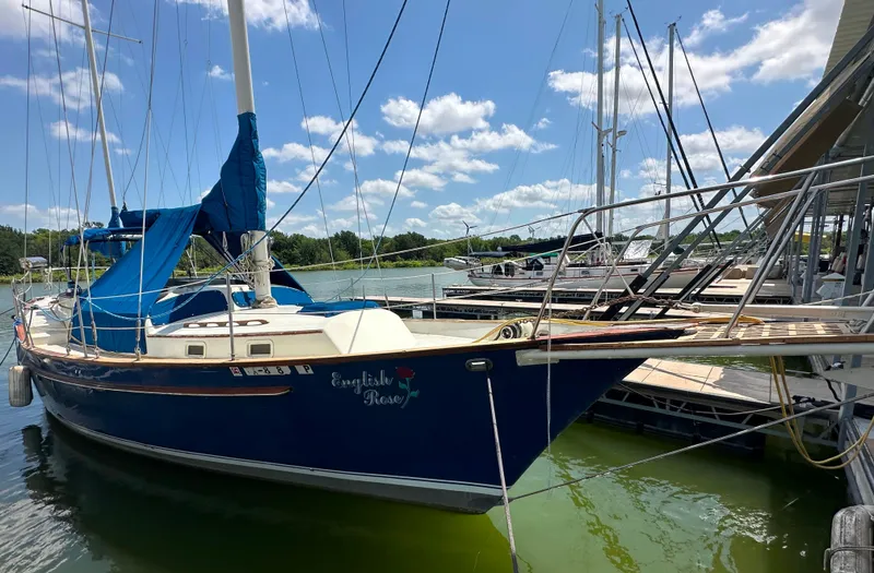 Slide: The Image of 1982 Irwin 46 sailboat docked, blue hull, clear sky, marina background. - 2