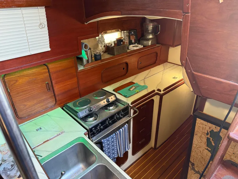 Slide: The Image of Cozy 1982 Irwin 46 yacht kitchen with stove, sink, and wooden cabinetry. - 25