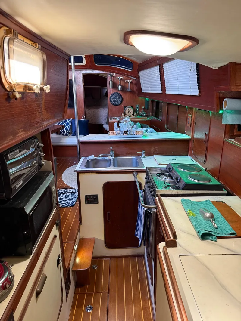Slide: The Image of Interior of 1982 Irwin 46 sailboat with wooden cabinetry and compact kitchen area. - 26