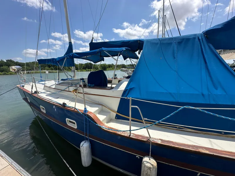 Slide: The Image of 1982 Irwin 46 sailboat docked, featuring blue canvas covers and clear skies. - 3