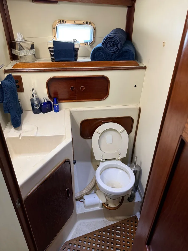 Slide: The Image of Compact bathroom in a 1982 Irwin 46 yacht with toilet, sink, and storage. - 36