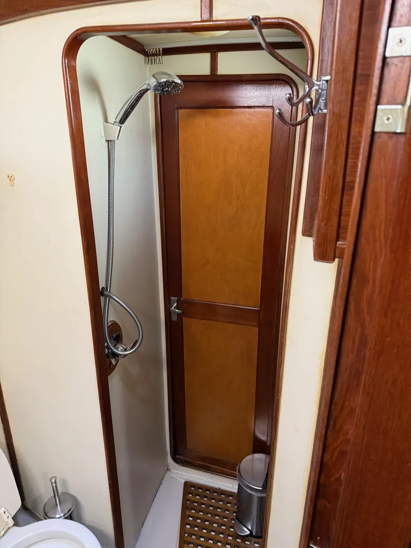 Slide: The Image of 1982 Irwin 46 yacht bathroom with shower, wooden door, and toilet. - 37