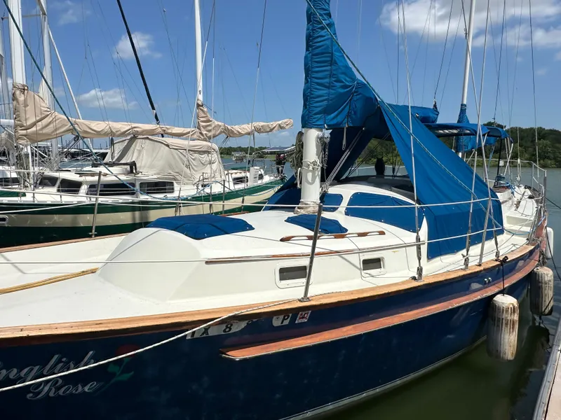 Slide: The Image of 1982 Irwin 46 sailboat docked, featuring blue and white design with covered sails. - 9