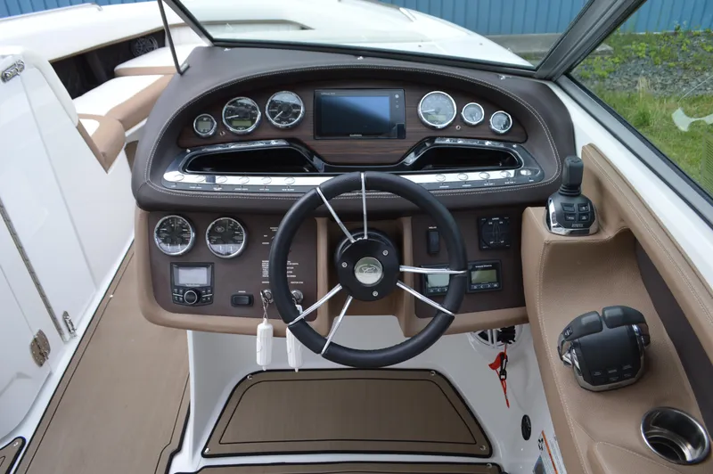 Slide: The Image of Interior dashboard of a 2016 Cobalt 302 boat, featuring steering wheel and control gauges. - 10