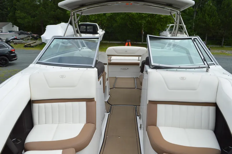 Slide: The Image of 2016 Cobalt 302 boat interior with white and tan seating, open deck, and windshield. - 22
