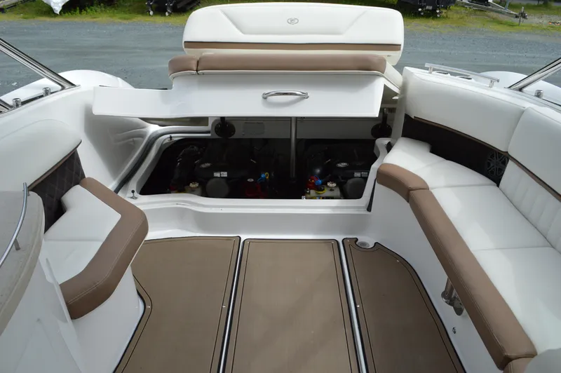 Slide: The Image of 2016 Cobalt 302 boat interior with open engine compartment, white and brown seating. - 32