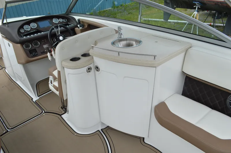 Slide: The Image of Interior of a 2016 Cobalt 302 boat featuring a helm, sink, and seating area. - 4