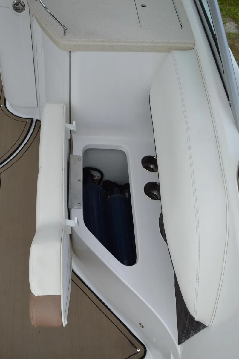 Slide: The Image of 2016 Cobalt 302 boat storage compartment with white cushioned seating. - 47