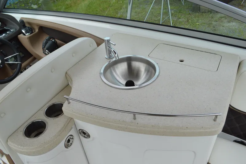 Slide: The Image of 2016 Cobalt 302 boat interior with sink and cup holders. - 6