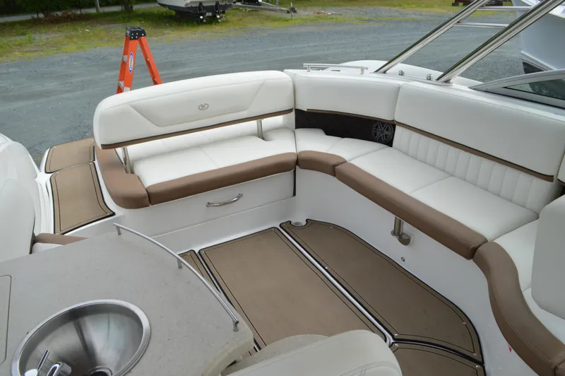 Slide: The Image of 2016 Cobalt 302 boat interior with white and brown seating, sink, and deck area. - 8
