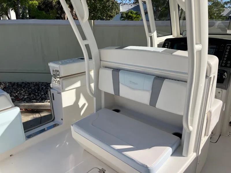 Slide: The Image of 2021 Robalo R272 Center Console boat interior with cushioned seating and control panel. - 11