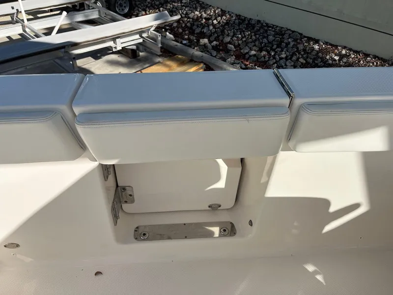 Slide: The Image of 2021 Robalo R272 Center Console boat interior with cushioned seating and storage compartment. - 13