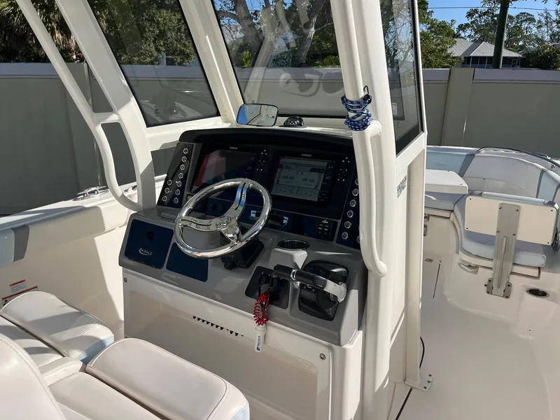 Slide: The Image of 2021 Robalo R272 Center Console boat interior with steering wheel and control panel. - 16