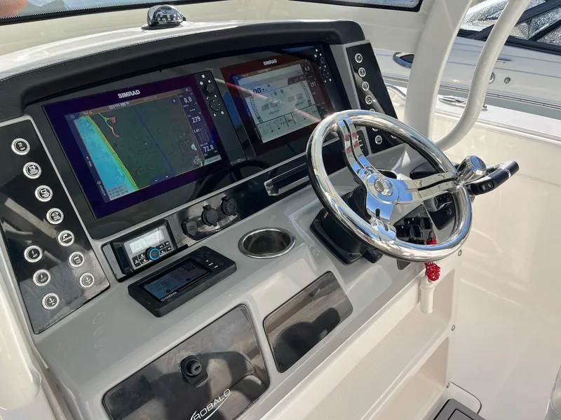Slide: The Image of 2021 Robalo R272 Center Console helm with dual navigation screens and stainless steel steering wheel. - 21