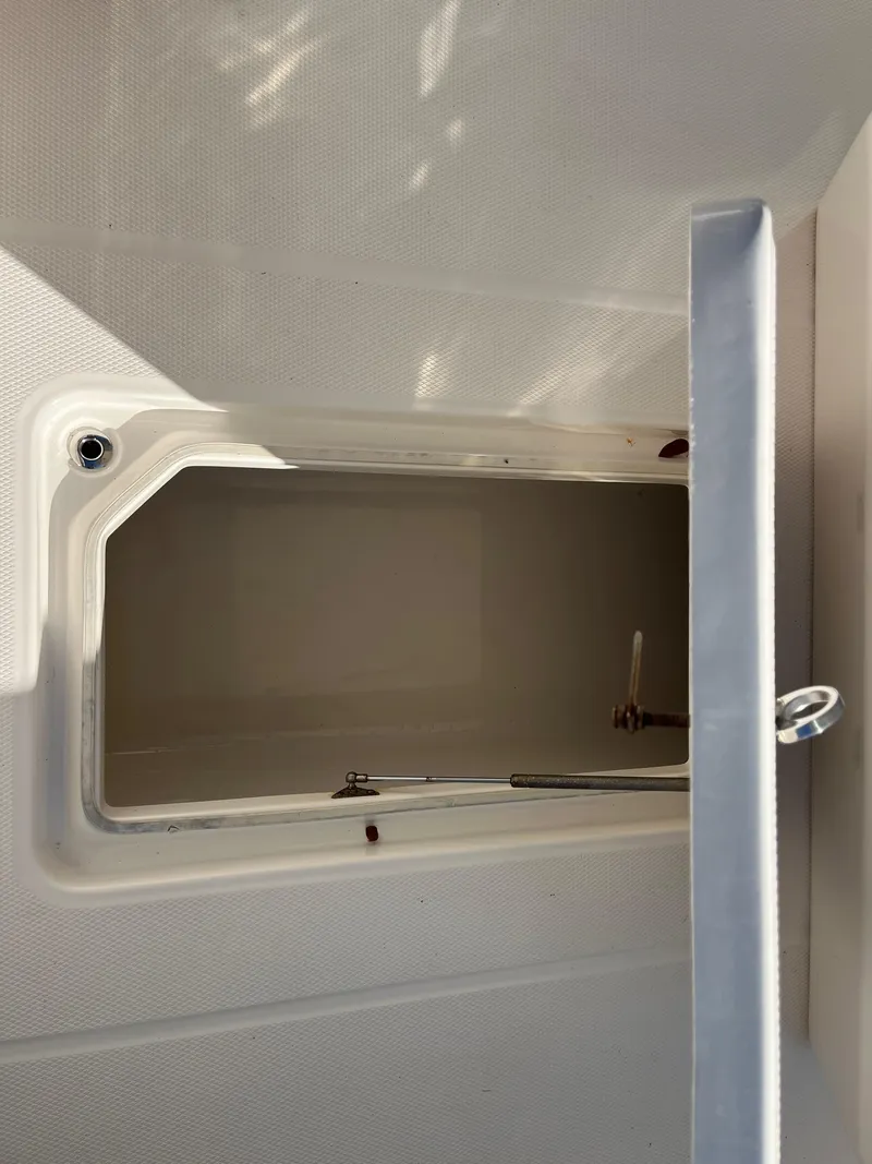 Slide: The Image of 2021 Robalo R272 Center Console storage compartment with open hatch. - 23