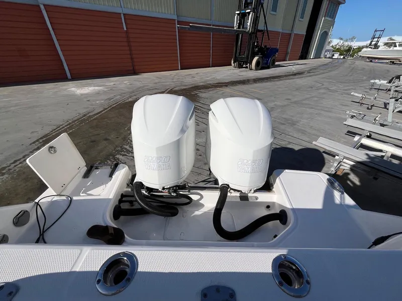 Slide: The Image of 2021 Robalo R272 Center Console boat with dual outboard engines, docked at a marina. - 25