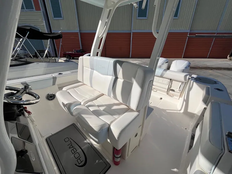 Slide: The Image of 2021 Robalo R272 Center Console boat interior with white seating and steering wheel. - 27