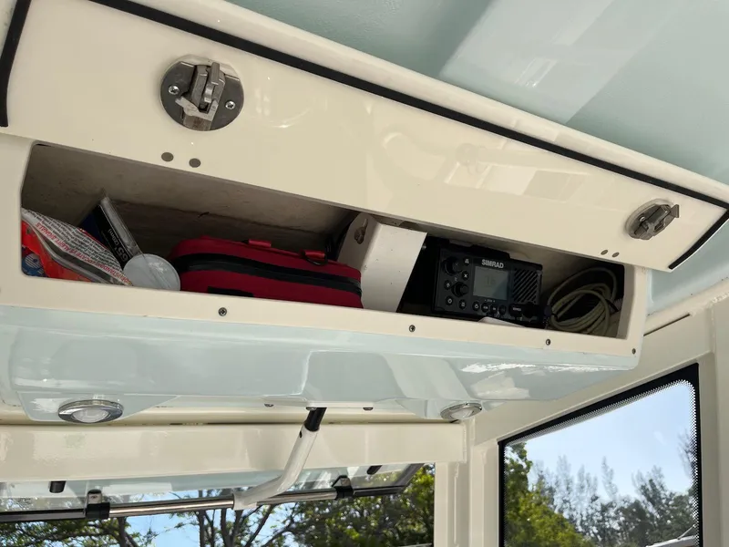 Slide: The Image of 2021 Robalo R272 Center Console storage compartment with equipment and supplies. - 28