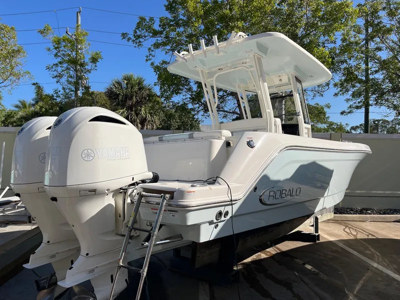 Slide: The Image of 2021 Robalo R272 Center Console boat with twin Yamaha engines, docked outdoors. - 3