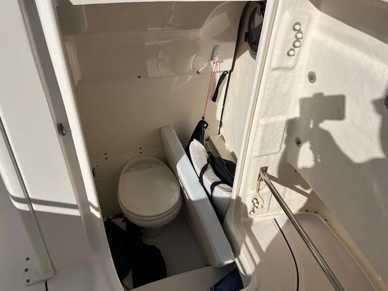 Slide: The Image of 2021 Robalo R272 Center Console boat interior with compact marine toilet. - 31