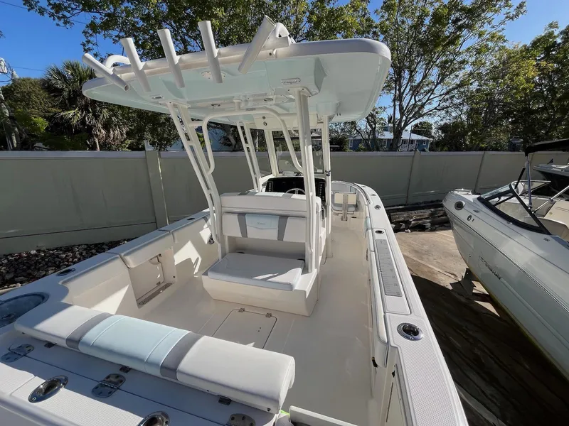 Slide: The Image of 2021 Robalo R272 Center Console boat with spacious deck and seating, docked outdoors. - 5