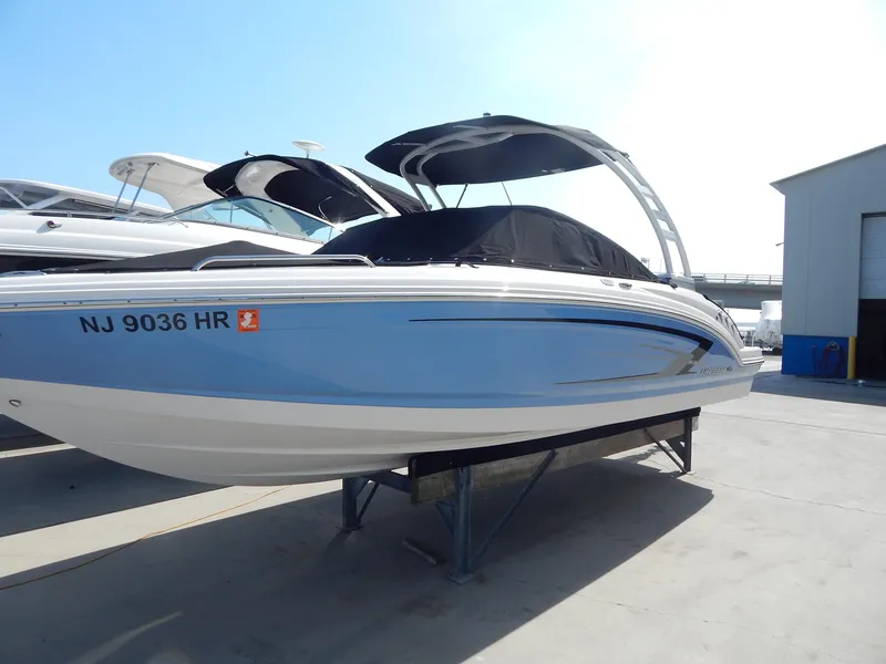 Slide: The Image of 2022 Chaparral 23 SSi OB boat with blue hull on display at marina. - 17