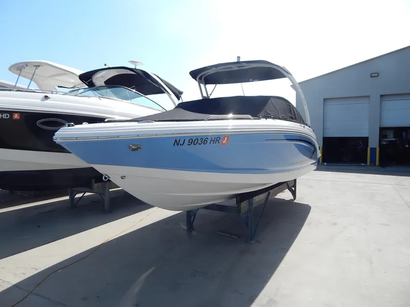 Slide: The Image of 2022 Chaparral 23 SSi OB boat on display in a marina setting. - 18