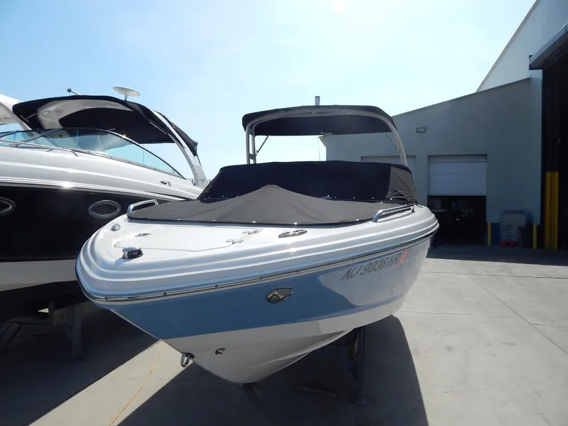 Slide: The Image of 2022 Chaparral 23 SSi OB boat with cover, parked outdoors near a building. - 19