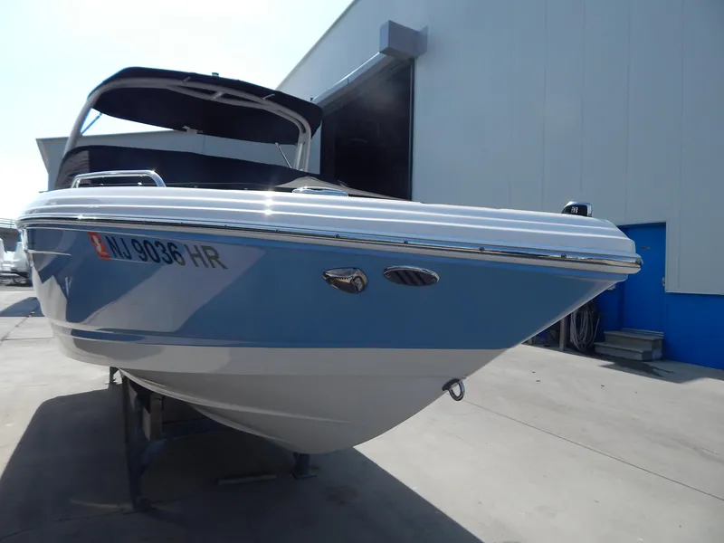 Slide: The Image of 2022 Chaparral 23 SSi OB boat in a marina, blue and white exterior. - 21